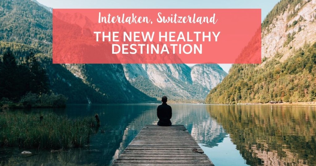 man sitting on a wood bridge over a lake looking at the mountain